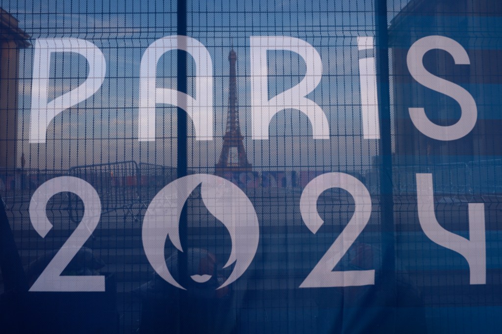 The Eiffel Tower is seen behind a Paris Olympics canvas, from the Trocadero plaza Thursday, July 18, 2024 in Paris. (AP Photo/David Goldman)