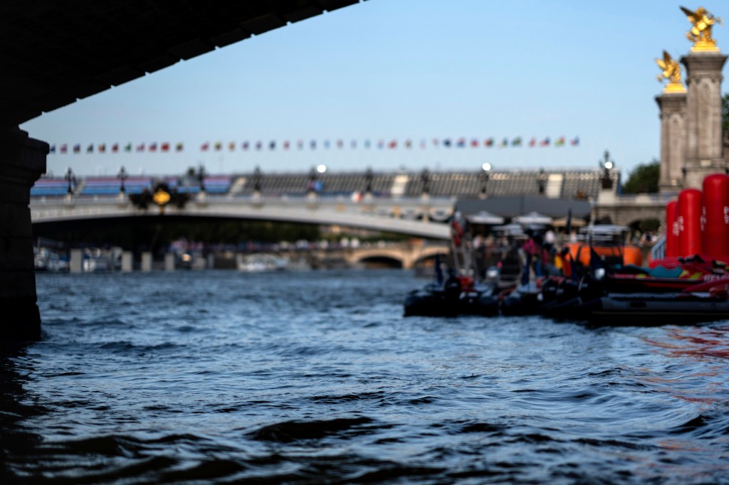 The Seine River flows in front of the Pont Alexandre III bridge, site of the triathlon events at the 2024 Summer Olympics, Monday, July 29, 2024, in Paris. As the Olympics continue in Paris, the Seine River's water quality remains a major area of concern for officials. Organizers of the triathlon event cancelled swimming practice on Monday for the second day in a row because of poor water quality. Event organizers hope sunny weather will make swimming viable on Tuesday when the triathlon begins. (AP Photo/David Goldman)