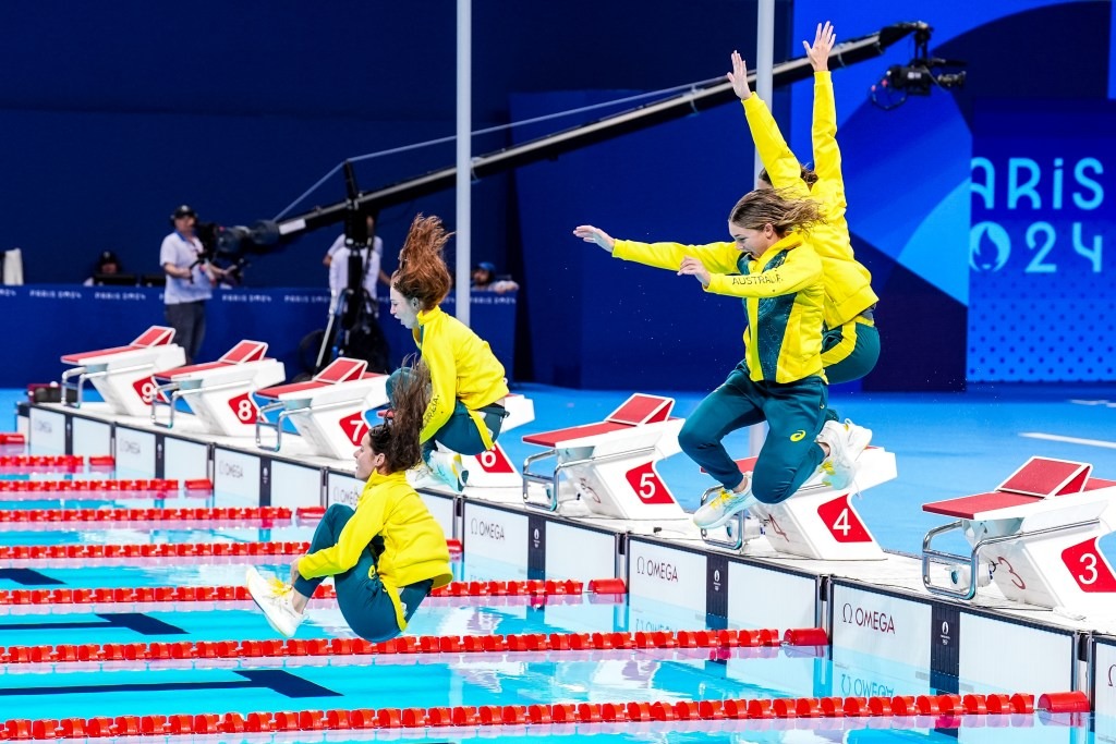 Silver Medalists Kaylee McKeown, Jenna Strauch, Emma McKeon and Mollie O’Callaghan jump in after the medal ceremony. Photo: Getty