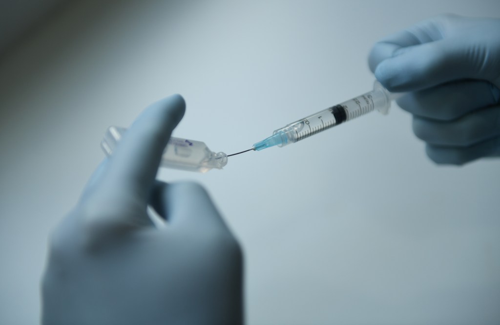A medical doctor is seen drawing fluid into a syringe in Essendon North, Melbourne, Tuesday, May 2, 2017. (AAP Image/Julian Smith) NO ARCHIVING