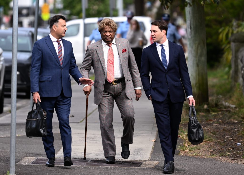 Kandiah Kamalesvaran, better known by his stage name Kamahl (centre), arrives at Sutherland Local Court in Sydney, Monday, October 14, 2024. Singer Kamahl has had charges for allegedly intimidating a woman over an unpaid $2000 loan dismissed, after a court heard the 89-year-old was mentally unstable. (AAP Image/Steven Markham) 